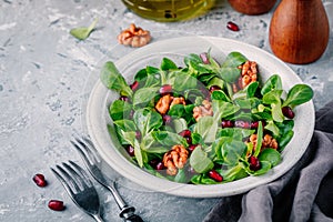 Healthy green Lambâ€™s lettuce salad with walnuts and pomegranate seeds