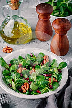 Healthy green Lambâ€™s lettuce salad with walnuts and pomegranate seeds