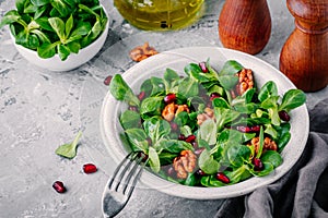 Healthy green Lambâ€™s lettuce salad with walnuts and pomegranate seeds