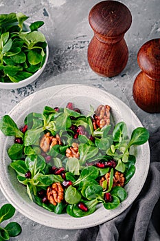 Healthy green Lambâ€™s lettuce salad with walnuts and pomegranate seeds