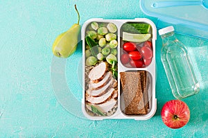 Healthy green meal prep containers with chicken fillet, rice, brussels sprouts and vegetables