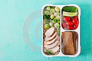 Healthy green meal prep containers with chicken fillet, rice, brussels sprouts and vegetables