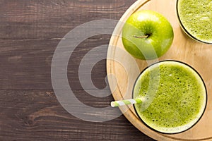 Healthy green smoothie with apple on rustic wood background