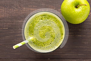 Healthy green smoothie with apple on rustic wood background