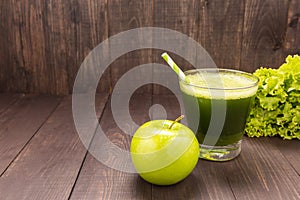 Healthy green smoothie with apple on rustic wood background