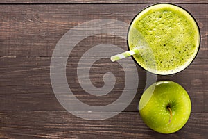 Healthy green smoothie with apple on rustic wood background