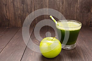 Healthy green smoothie with apple on rustic wood background