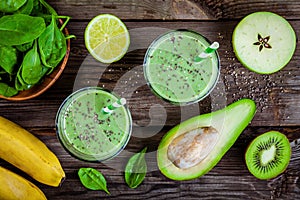 Healthy green smoothie with banana, spinach, avocado and chia seeds in glass jars