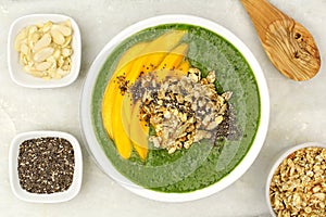 Healthy green smoothie bowl overhead view on granite