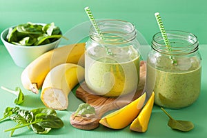 Healthy green smoothie with spinach mango banana in glass jars