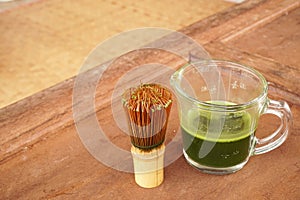 Healthy green tea in cup and bamboo whisk.