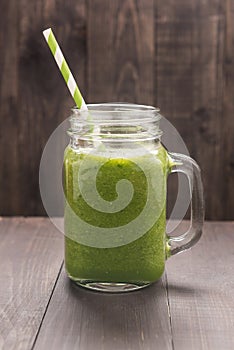 Healthy green vegetables and green fruit smoothie on rustic wood