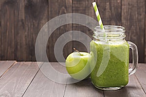 Healthy green vegetables and green fruit smoothie on rustic wood