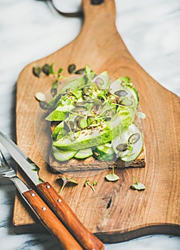 Healthy green veggie sandwich with avocado on board