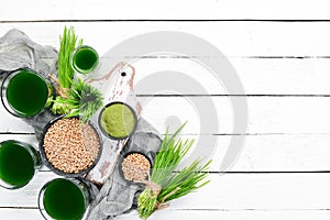 Healthy green wheat drink on a white background. Top view.