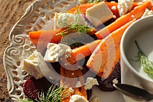 Healthy grilled beet, carrots salad with cheese feta, fennel and Greek yogurt in small glass bowls on the rustic wooden