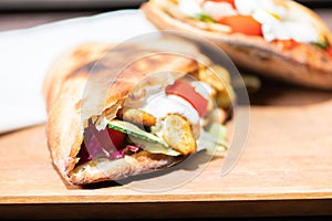 Healthy grilled chicken sandwich with homemade baguette on a wooden plate