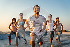 Healthy group of fit multiethnic friends exercising together outdoors. Sport people fun concept.