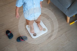 Healthy habits begin: Multiracial toddler weighing in at home