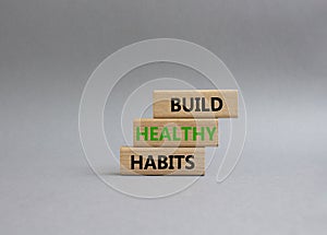 Healthy habits symbol. Concept word Build Healthy habits on wooden blocks. Beautiful grey background. Healthy lifestyle and