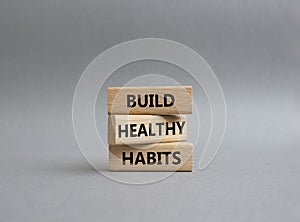 Healthy habits symbol. Concept word Build Healthy habits on wooden blocks. Beautiful grey background. Healthy lifestyle and