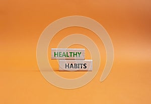 Healthy habits symbol. Concept word Healthy habits on wooden blocks. Beautiful orange background. Business and Healthy habits