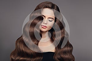 Healthy hair. Brunette girl portrait with long shiny wavy hair.