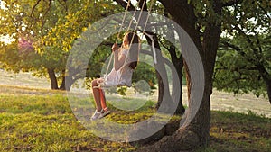 Healthy Happy Baby Boy. little girl is playing on a swing in a park on a tree. dream of flying. The concept of a happy