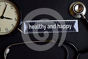 Healthy and Happy on the print paper with Healthcare Concept Inspiration. alarm clock, Black stethoscope.