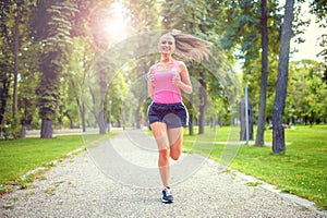 Healthy and happy woman running in urban park