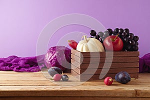 Healthy harvest concept.  Pumpkin, apple, grapes and vegetables in wooden box on table.  Autumn still life