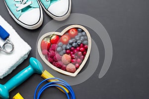 Healthy heart diet and sport gym equipment concept on blackboard