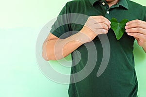 Healthy heart, love for environment and environmental conservationist concept. Young Asian man hands holding a green heart shape