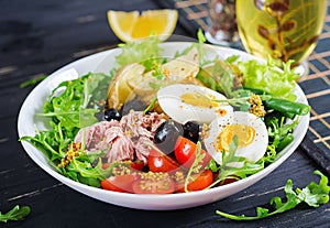 Healthy hearty salad of tuna, green beans, tomatoes, eggs, potatoes, black olives