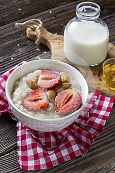 Healthy homemade breakfast. Fresh milk porridge with garden ripe strawberries