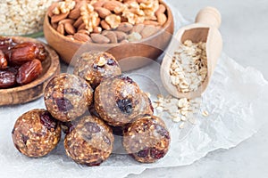 Healthy energy balls with cranberries, nuts, dates and rolled oats on parchment, horizontal, copy space