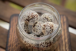 Healthy homemade energy balls with cranberries, nuts, dates and rolled oats on parchment, horizontal