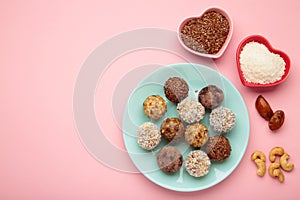 Healthy homemade energy balls with cranberries, nuts, dates and rolled oats on pink background. Space for text