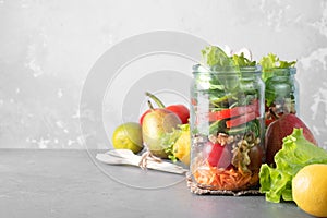 Healthy homemade mason jar salad with fresh pear tomatoes, carrots and herbs. Vegetarian concept