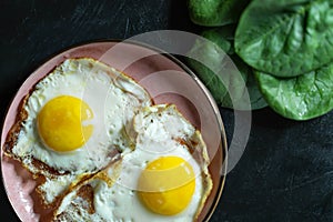 Healthy homemade scrambled eggs with spinach on a dark background.