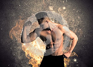 Healthy hot male showing muscles with fire