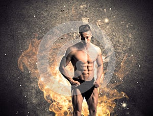 Healthy hot male showing muscles with fire