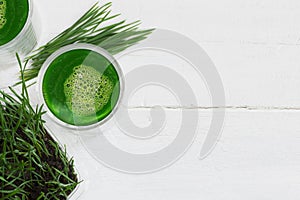 Healthy ingredients for detox, wheatgrass juice with young shoots of the wheat plant isolated on white background with copy space