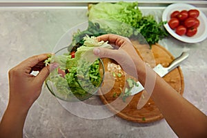 Healthy ingredients for raw vegan salad. Close-up of female chef hands preparing raw vegan salad at home kitchen. Food and concept