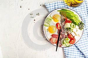 Healthy keto diet breakfast: egg, avocado, cheese, bacon and fresh salad on white plate. eto, paleo breakfast. Top view, copy