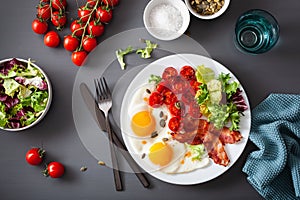 Healthy keto diet breakfast: egg, tomatoes, salad leaves and bacon