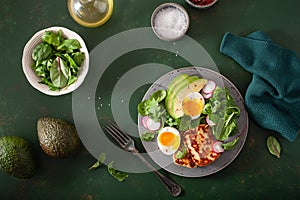 Healthy keto paleo diet breakfast: boiled egg, avocado, halloumi cheese, salad leaves