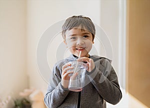 Healthy kid drinking juice, High key light portrait Cute funny boy drinking a fresh soda drink through a straw, Happy child