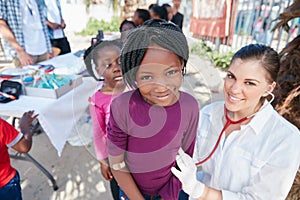 Healthy kids are happy kids. Portrait of volunteer nurses giving checkups to underprivileged kids. photo