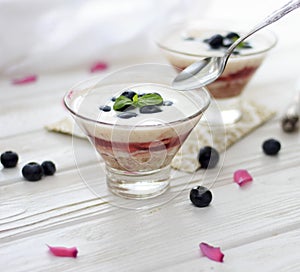 Healthy layered dessert with cream, strawberries and blueberries